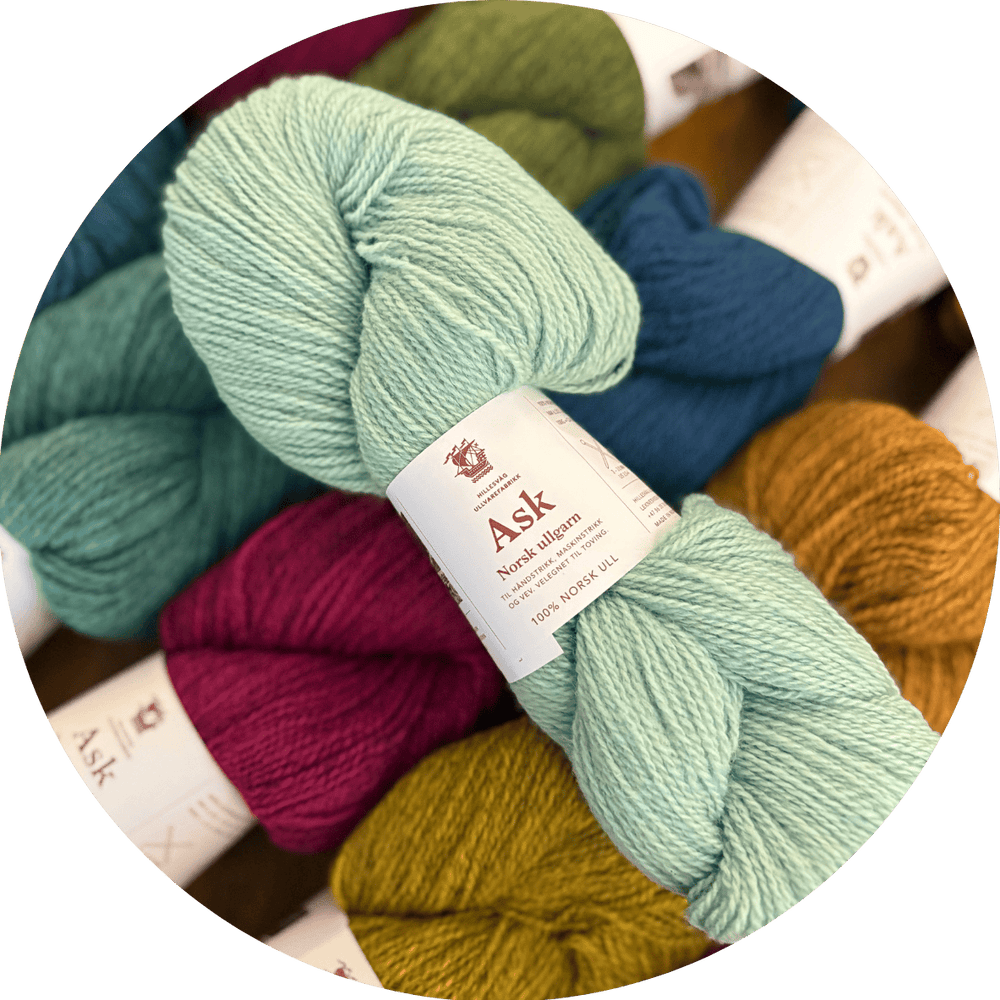 Hillesvåg Ask Norwegian yarn. A seafoam green skein shown on top of other skeins in many colors.
