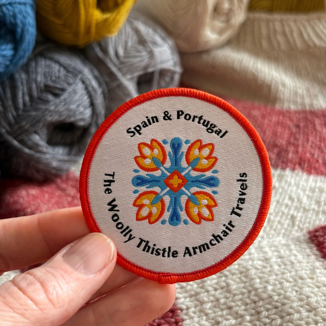 Embroidered patch with colorful design and text 'Spain & Portugal The Woolly Thistle Armchair Travels'