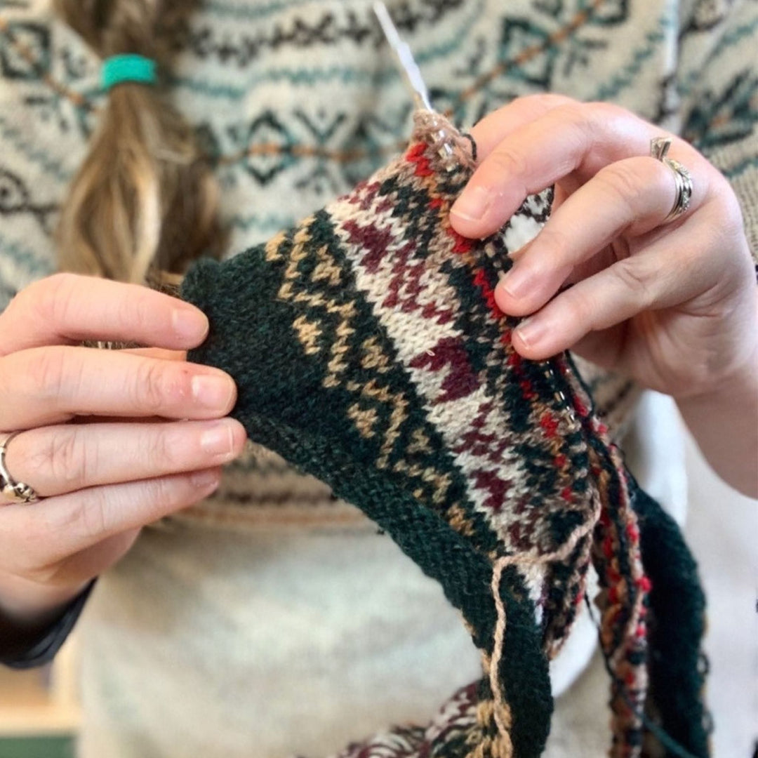 hands knitting Fair Isle design Hairst Cushion by Wilma Malcolmson. Sweater shown Yokey Dokey by Gudrun Johnston. 