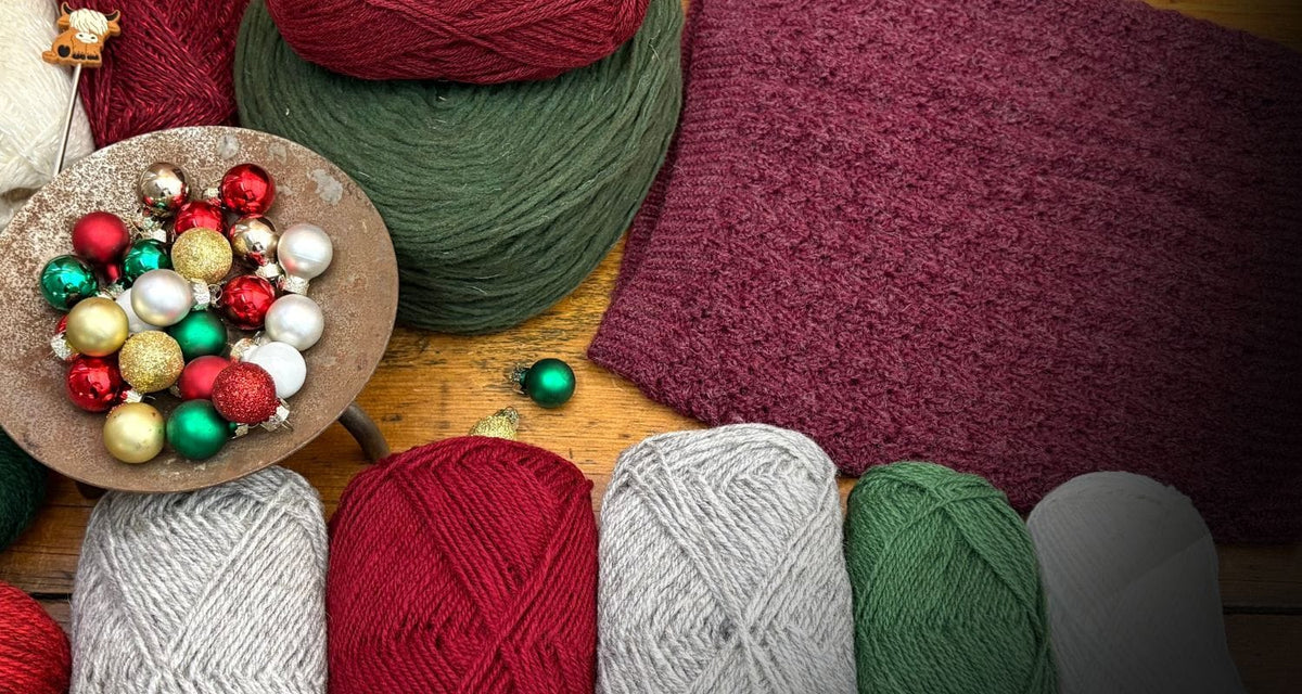 Christmas ornaments with red and green yarn next to knit fabric.