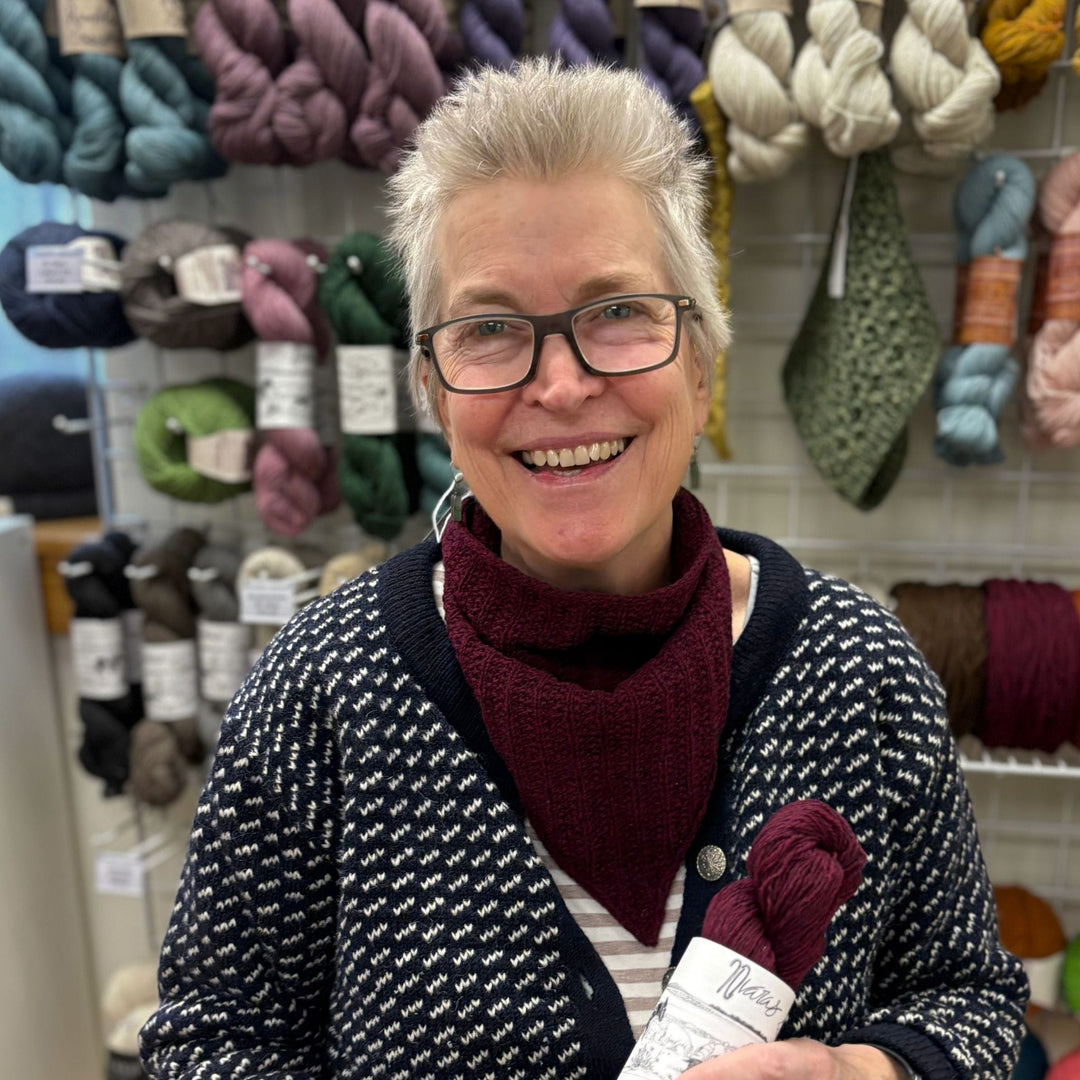 Woman, knitting instructor, smiling in yarn store.