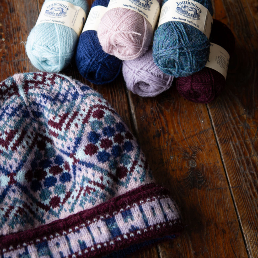 Birsie Beanny handknit colorwork hat shown with balls of Jamieson's of Shetland Spindrift yarn.