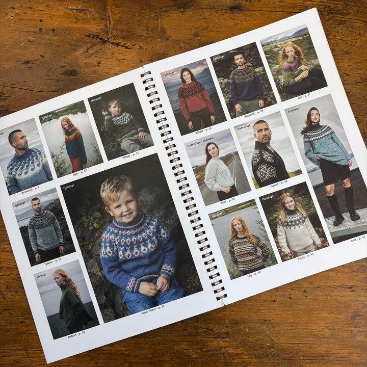 Spiral-bound book, Lopi Book 45, laying open on wooden surface. Pages show  images of people wearing knitted sweaters.