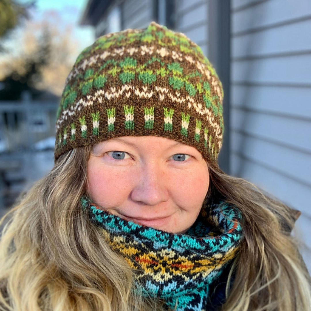 Person wearing the Shamrock Hat by Cait St. George knit in Jamieson & Smith 2-ply Jumper Weight wool with green shamrock colorwork.