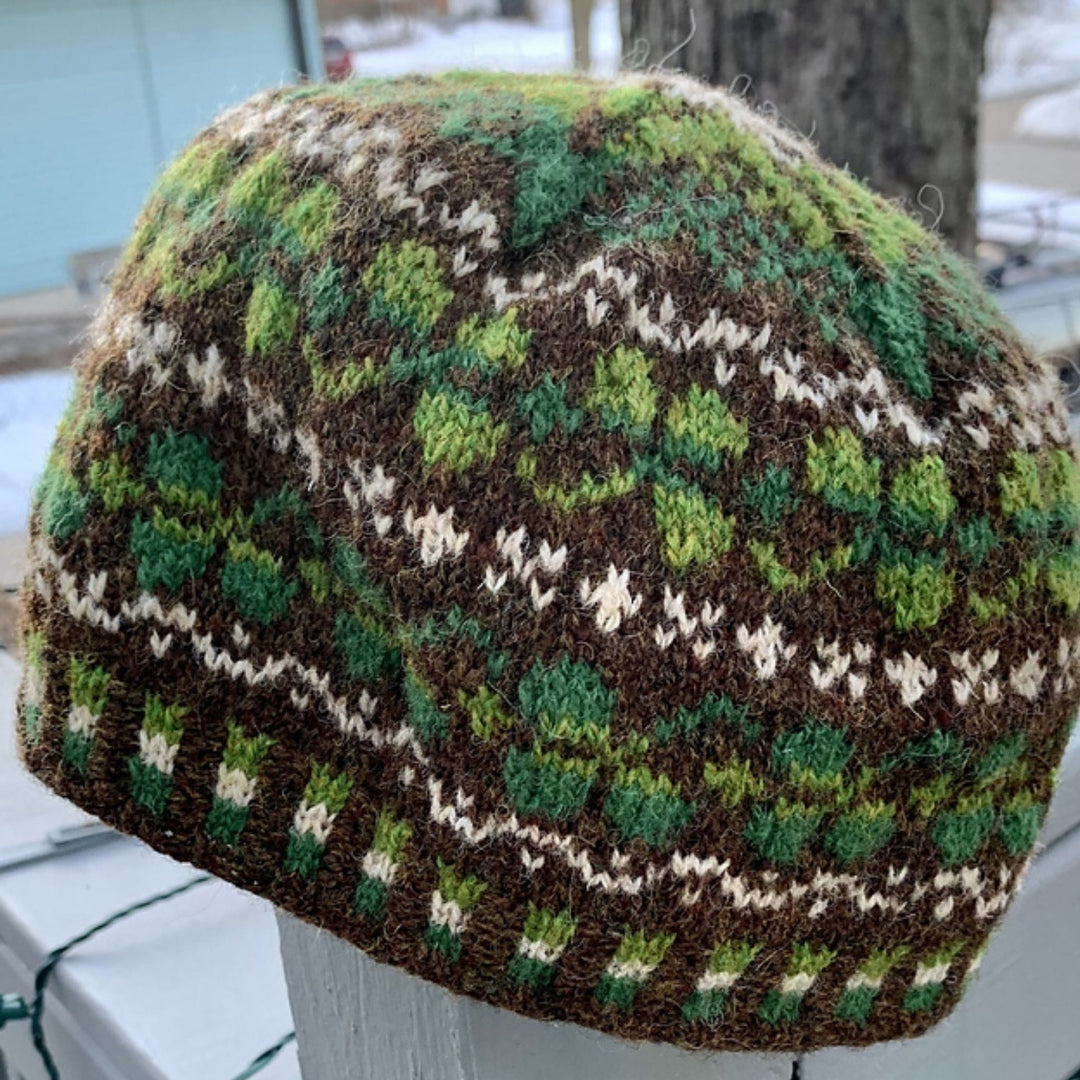 Close view of knitted Shamrock Hat with green and brown pattern in an outdoor setting