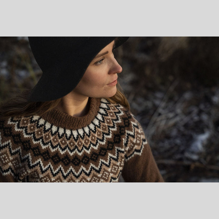 Woman wearing a patterned sweater and black beanie in a natural setting. This is a page from Laine Book "Unfolding Landscapes"