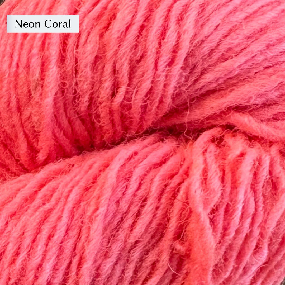Close-up of Lichen & Lace Rustic Sport yarn in bright pink color labeled 'Neon Coral'