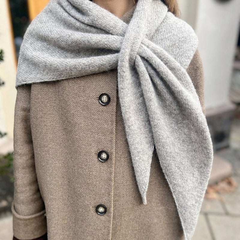 Magdalenasjal shawl knit in Rauma Finullgarn, styled as a soft gray triangular scarf over a coat.