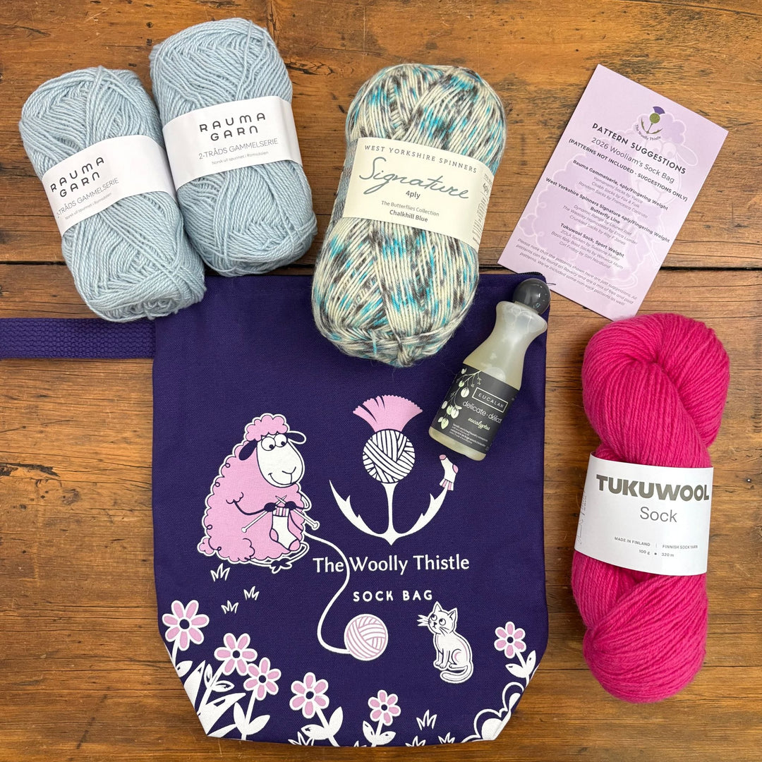 The Woolly Thistle Sock Bag shown with all the yarn components in a variety of colors and the small bottle of Eucalan and Pattern Suggestion Card.
