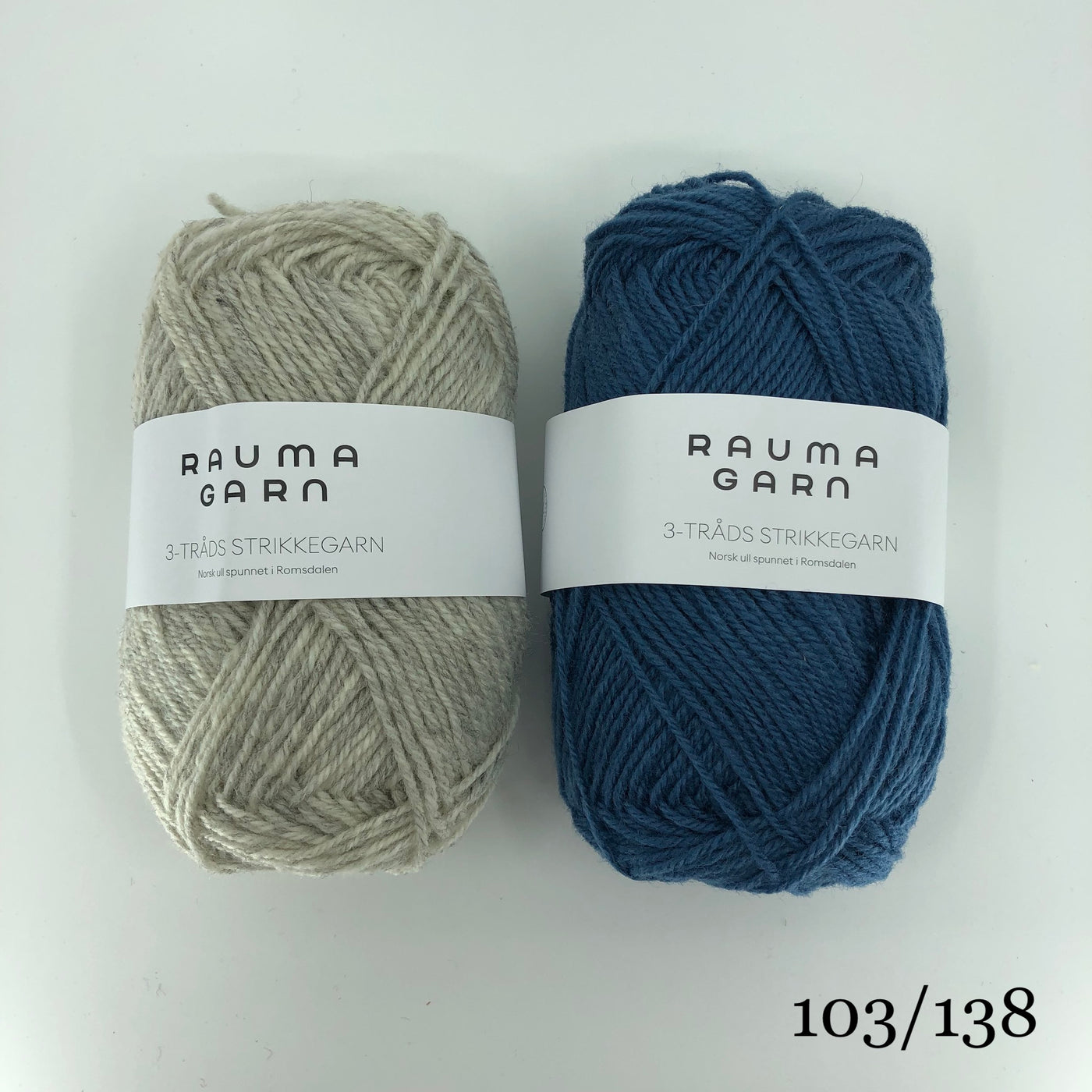 The Woolly Thistle Bladjakke Cardigan 288-1 in Rauma Strikkegarn and 2 balls of yarn in beige and blue.