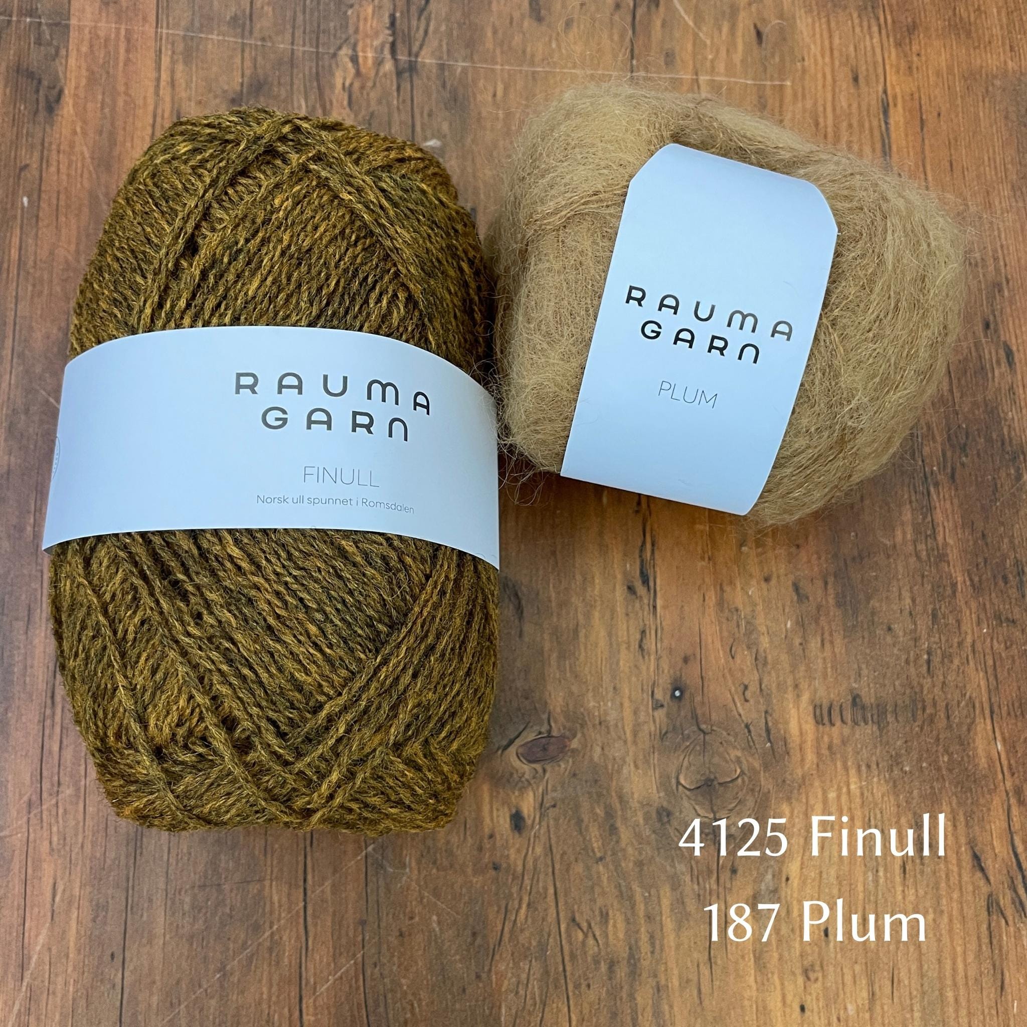 Ball of Rauma Finullgarn yarn in heathered gold with coordinating Plum yarn 