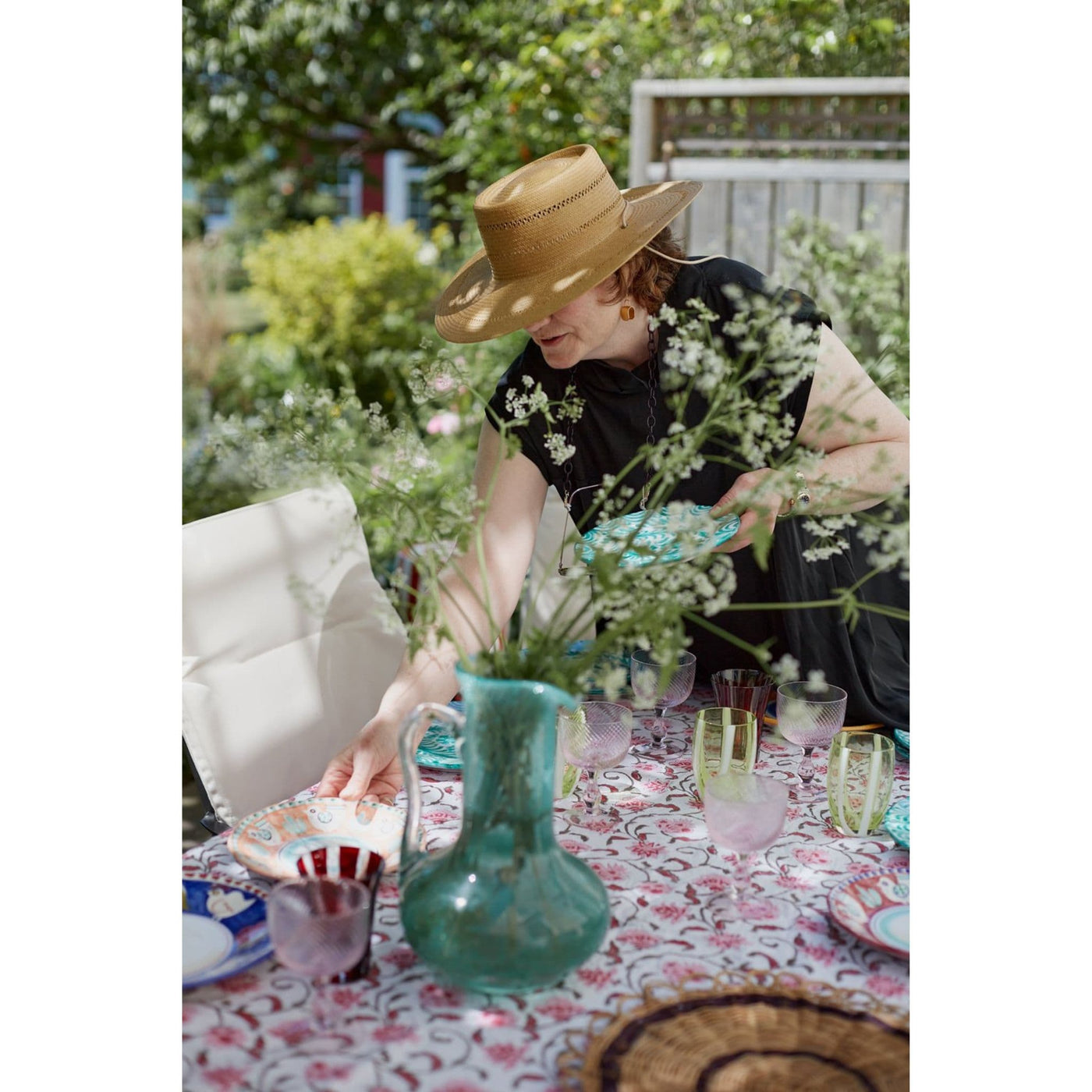 Inside page of Faire Press Magazine Issue 7. Woman arranging dishes on table outdoors. 