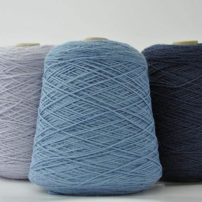 3 cones of Frangipani 5-ply Guernsey Wool Yarn in shades of blue.