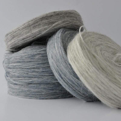 4 stacked plates Plötulopi Unspun Wool in shades of gray.