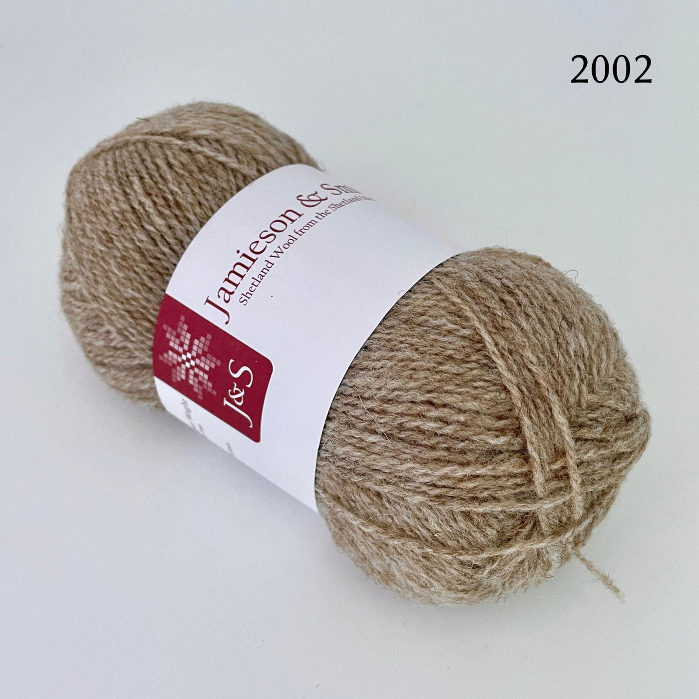 A ball of Jamieson & Smith Shetland Supreme, a fingering weight wool yarn, in color 2002, Mooskit, a light tan