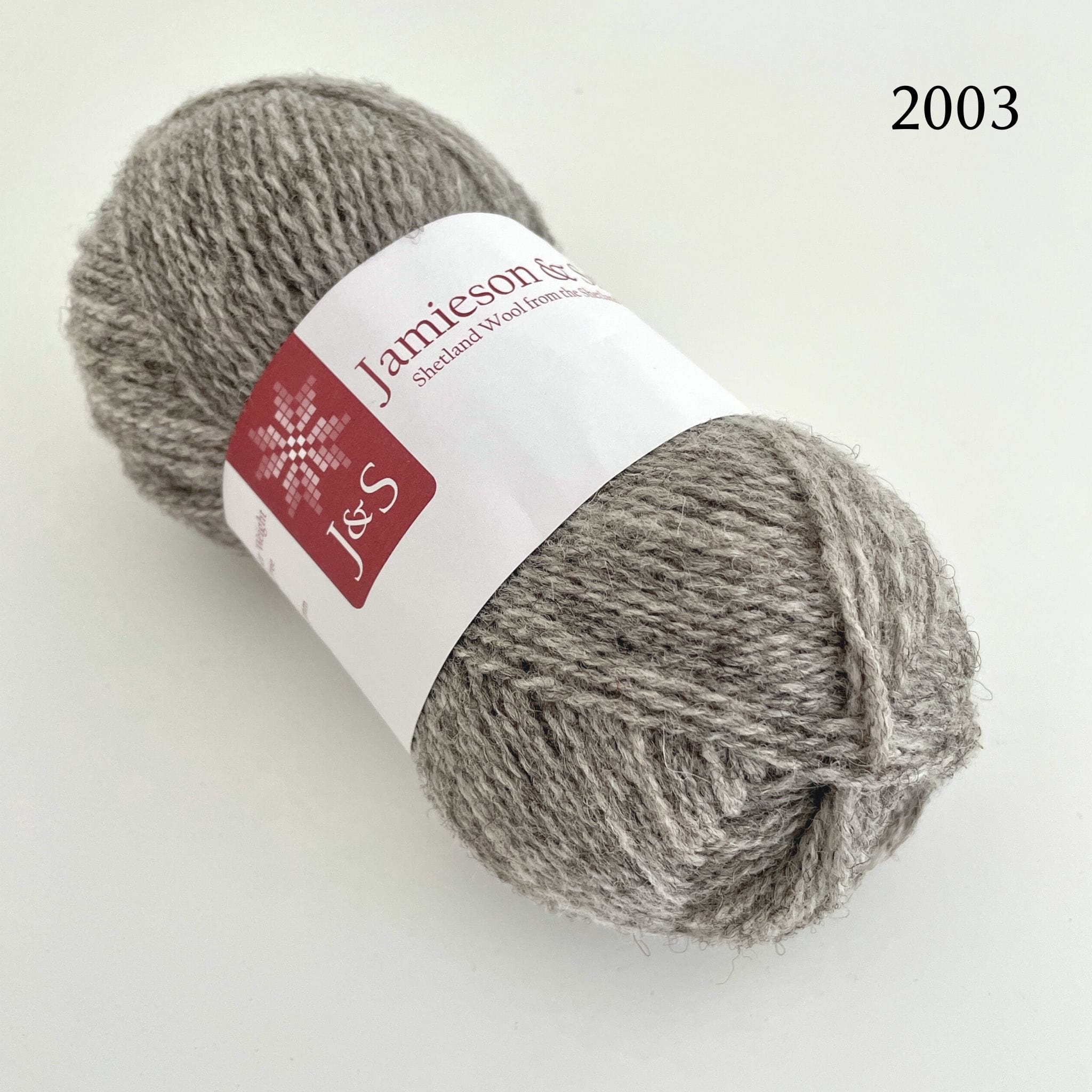 A ball of Jamieson & Smith Shetland Supreme, a fingering weight wool yarn, in color 2003, a light grey