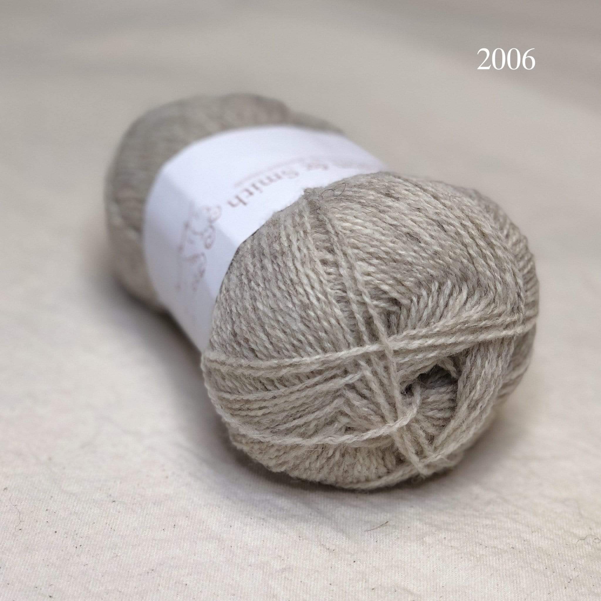 A ball of Jamieson & Smith Shetland Supreme, a fingering weight wool yarn, in color 2006, Gaulmogit, a very light grey
