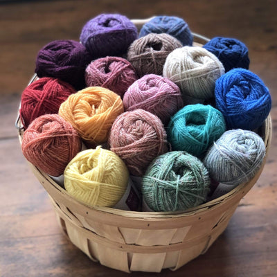 Basket of 17 balls of Jamieson & Smith 2ply Jumper Weight, light fingering weight yarn, in a range of colors