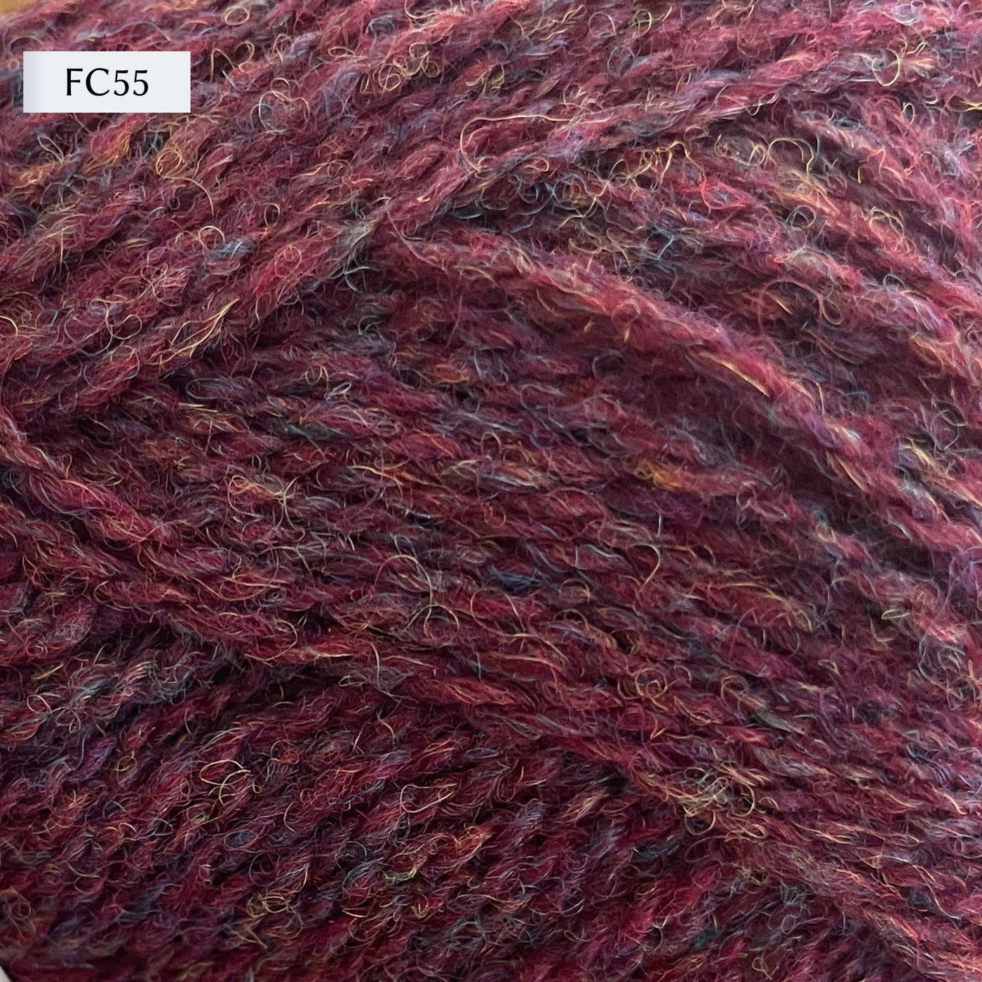 Jamieson & Smith 2ply Jumper Weight, light fingering weight yarn, in color FC55, a maroon heathered with purple, black, and orange