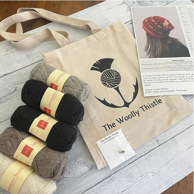 Components of the Tirval's Toorie Kit. Jamieson & Smith Heritage yarn in neutrals shown with The Woolly Thistle Tote Bag, Stitch Marker, and the print pattern for Tirval's Toorie.. 