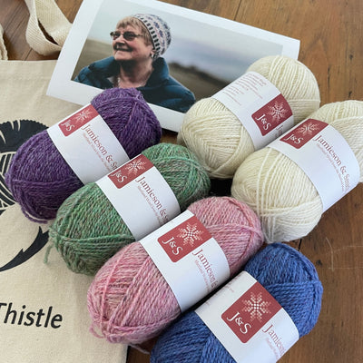 Wilma Malcomson's Katie's Kep Set components shown including close view of 6 balls of Jamieson and Smith yarn shown with photo of woman wearing the kep and a TWT tote bag.