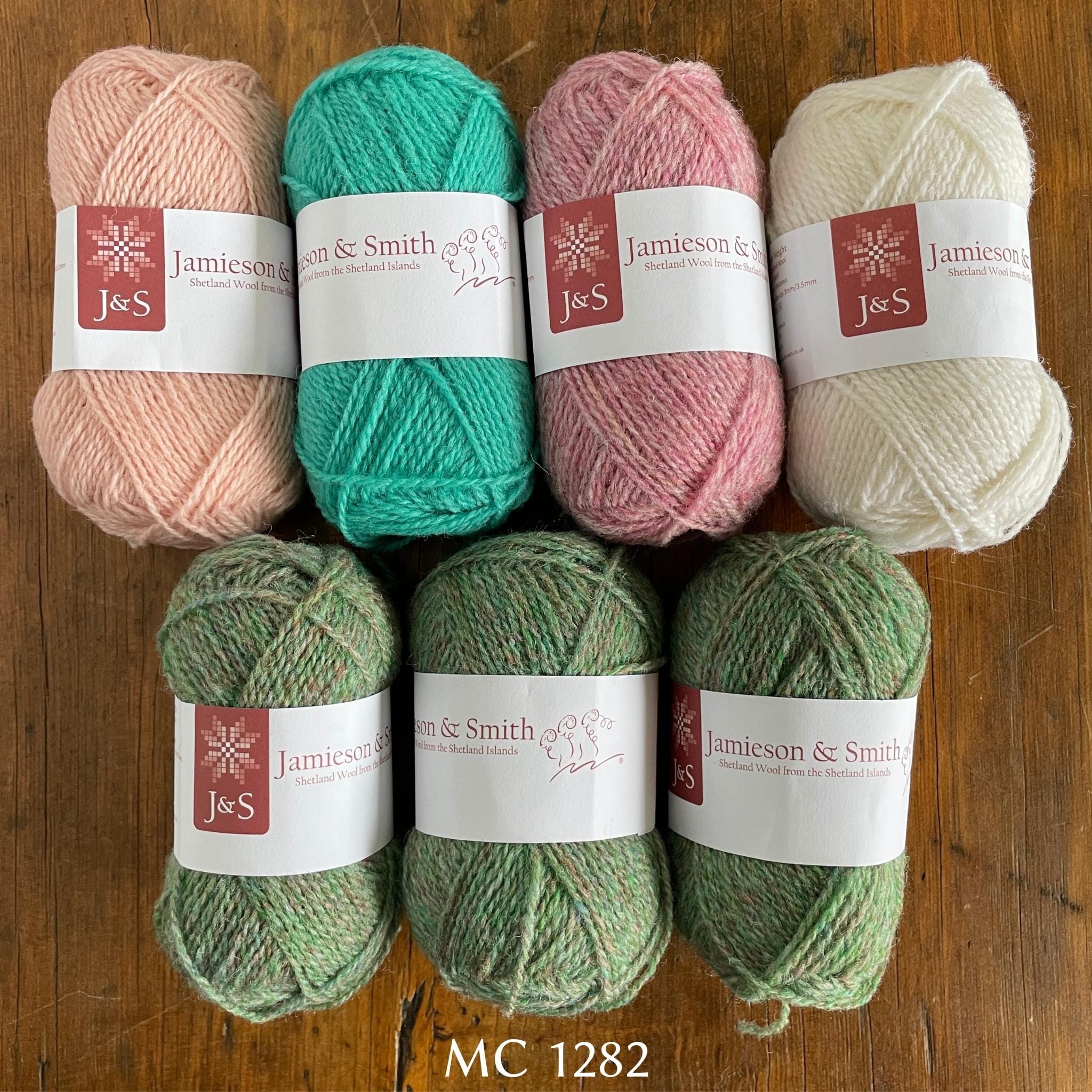 7 balls of J&S yarn in heathered green and pink, light turquoise, and white