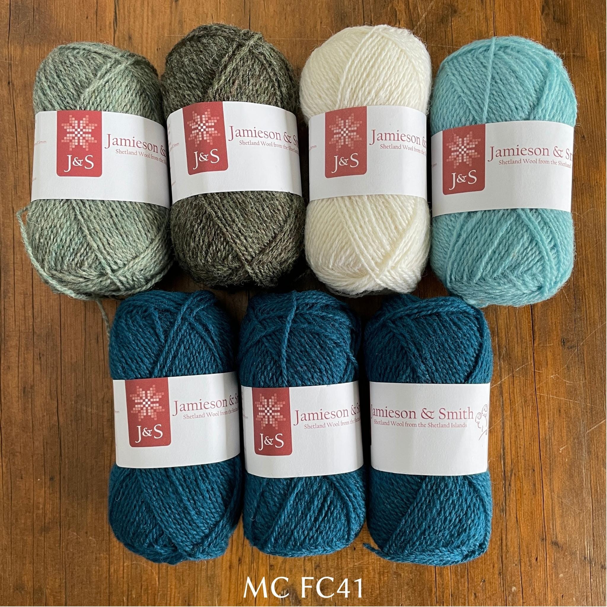 7 balls of J&S yarn in deep turquoise, grey, two light blues, and white
