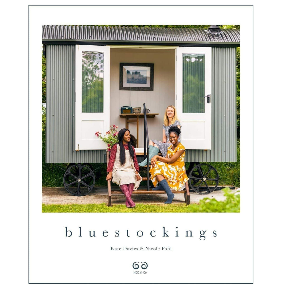 The Woolly Thistle Bluestockings by Kate Davies & Nicole Pohl cover which features 3 women wearing long knitted socks in burgundy, dark blue, and light blue