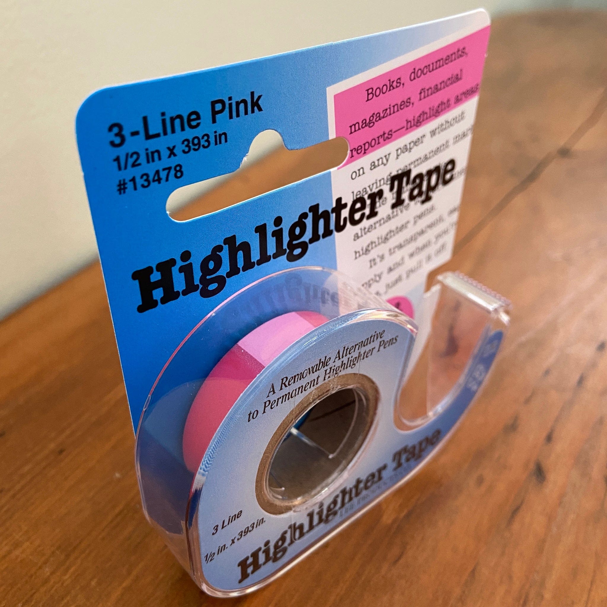 Package of pink highlighter tape sitting on table.