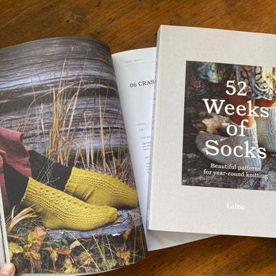 The Woolly Thistle 52 Weeks of Socks: Beautiful Patterns for year-round knitting- paperback edition spread displaying yellow knitted socks