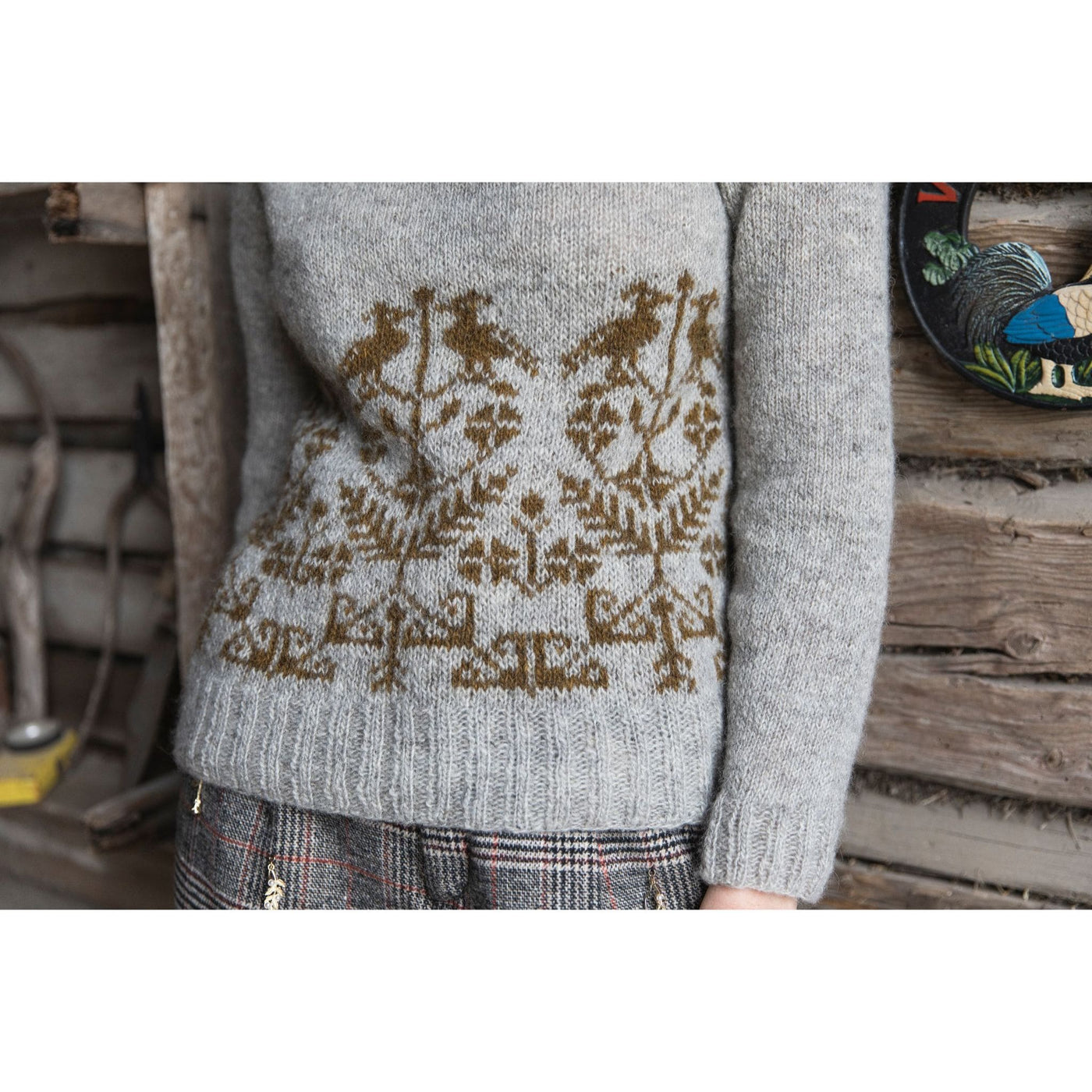 Knitted Kalevala book by Jenna Kostet from Laine Publishing. A design from book is shown - body of sweater shown on model with grey and gold colorwork.