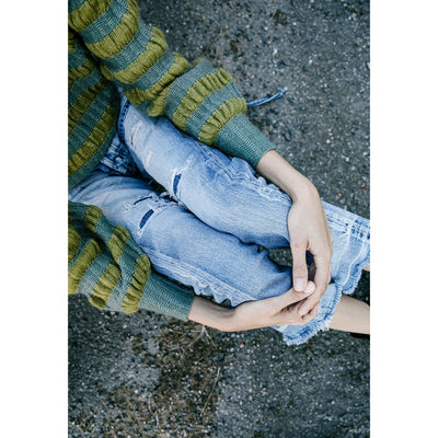 Inside Laine Magazine Issue 15 Autumn 2022 aerial view of woman wearing off jeans and blue & green sweater sitting on the ground.