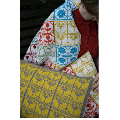 Page from The Knitted Fabric by Dee Hardwicke showing a blanket and pillows in multiple colors of a colorwork motif