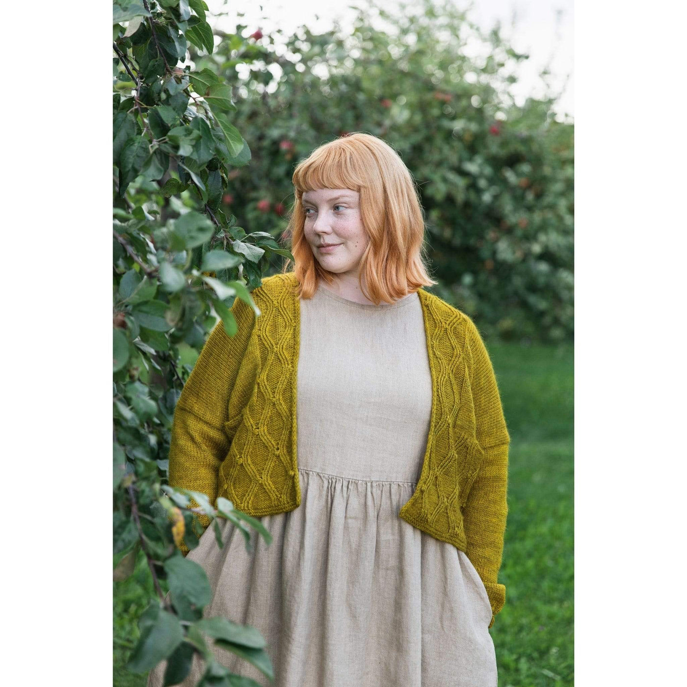 The Woolly Thistle Worsted – A Knitwear Collection Curated by Aimée Gille of La Bien Aimée published by Laine woman wearing mustard yellow knitted cardigan