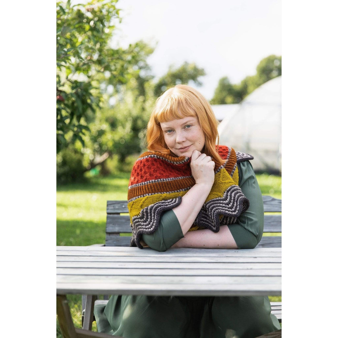 The Woolly Thistle Worsted – A Knitwear Collection Curated by Aimée Gille of La Bien Aimée published by Laine woman wearing  red, brown, yellow, and black and white striped shawl