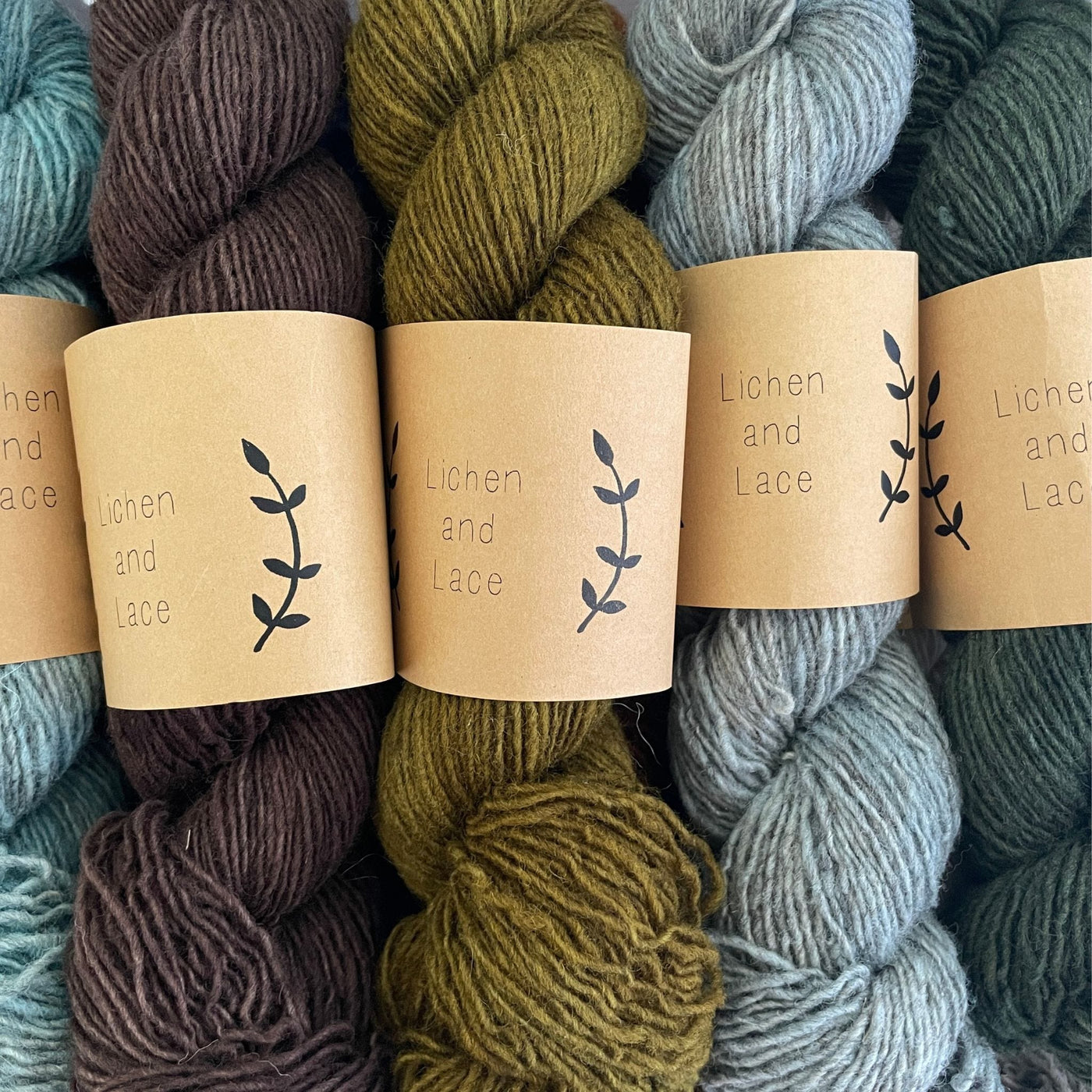 Several skeins of Lichen & Lace Rustic Heather Sport, a sport weight single-ply yarn
