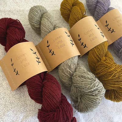 Four skeins of Lichen & Lace Rustic Heather Sport, a sport weight single-ply yarn,