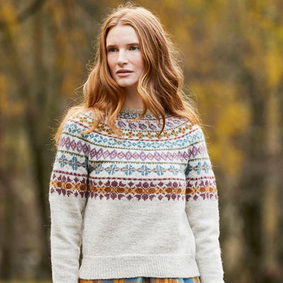 model standing outside wearing Catbells Sweater by Marie Wallin; main color of sweater is raw with multicolor design on top