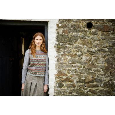 Model standing outside wearing Keris, an allover colorwork sleeveless sweater desinged by Marie Wallin in her new collection, Cumbria