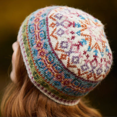 Female model wearing Tarn Tam, an allover colorwork hat designed by Marie Wallin in her new collection, Cumbria. This hat shown with Raw as main color