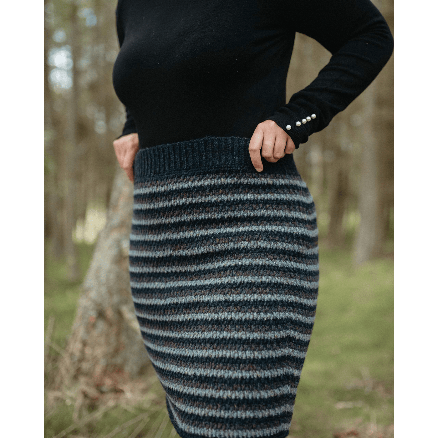 The Woolly Thistle Moorit Magazine - Issue 1 image from magazine showing woman wearing knitted blue striped patterned skirt
