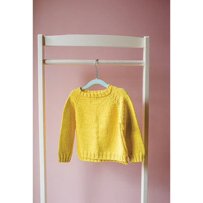Pattern in minipom magazine shows yellow knit sweater hanging against pink background.