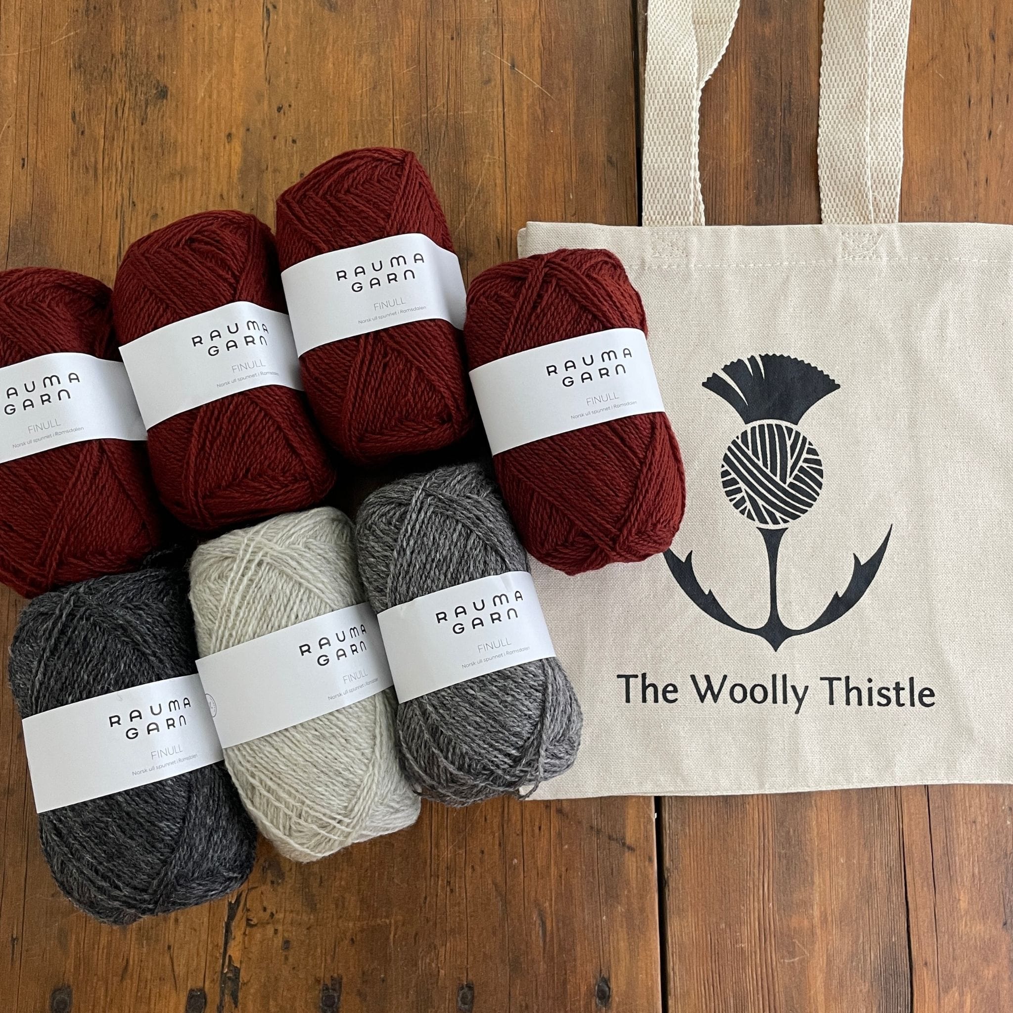 Components of the Varde Skirt Kit including TWT Tote, and Rauma Finullgarn yarn in Burgundy and greys.