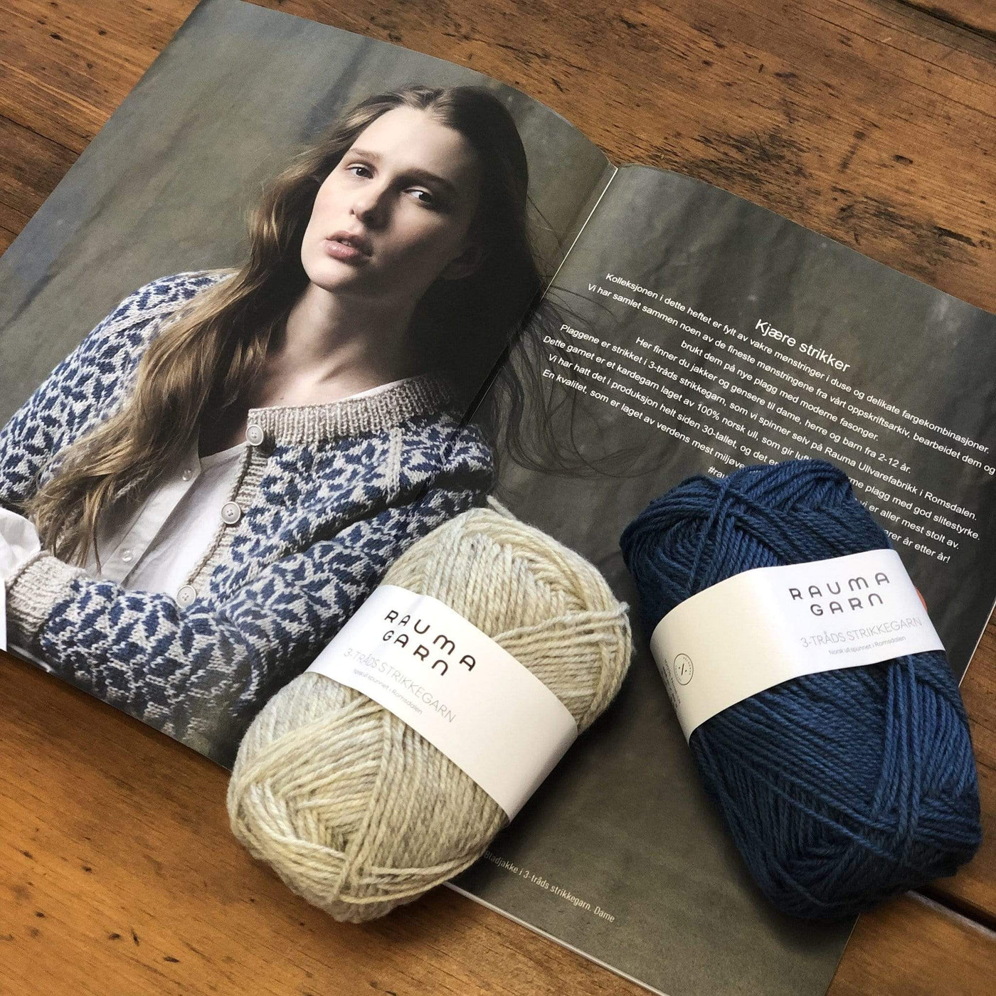 The Woolly Thistle Bladjakke Cardigan 288-1 in Rauma Strikkegarn and 2 balls of yarn in beige and dark blue