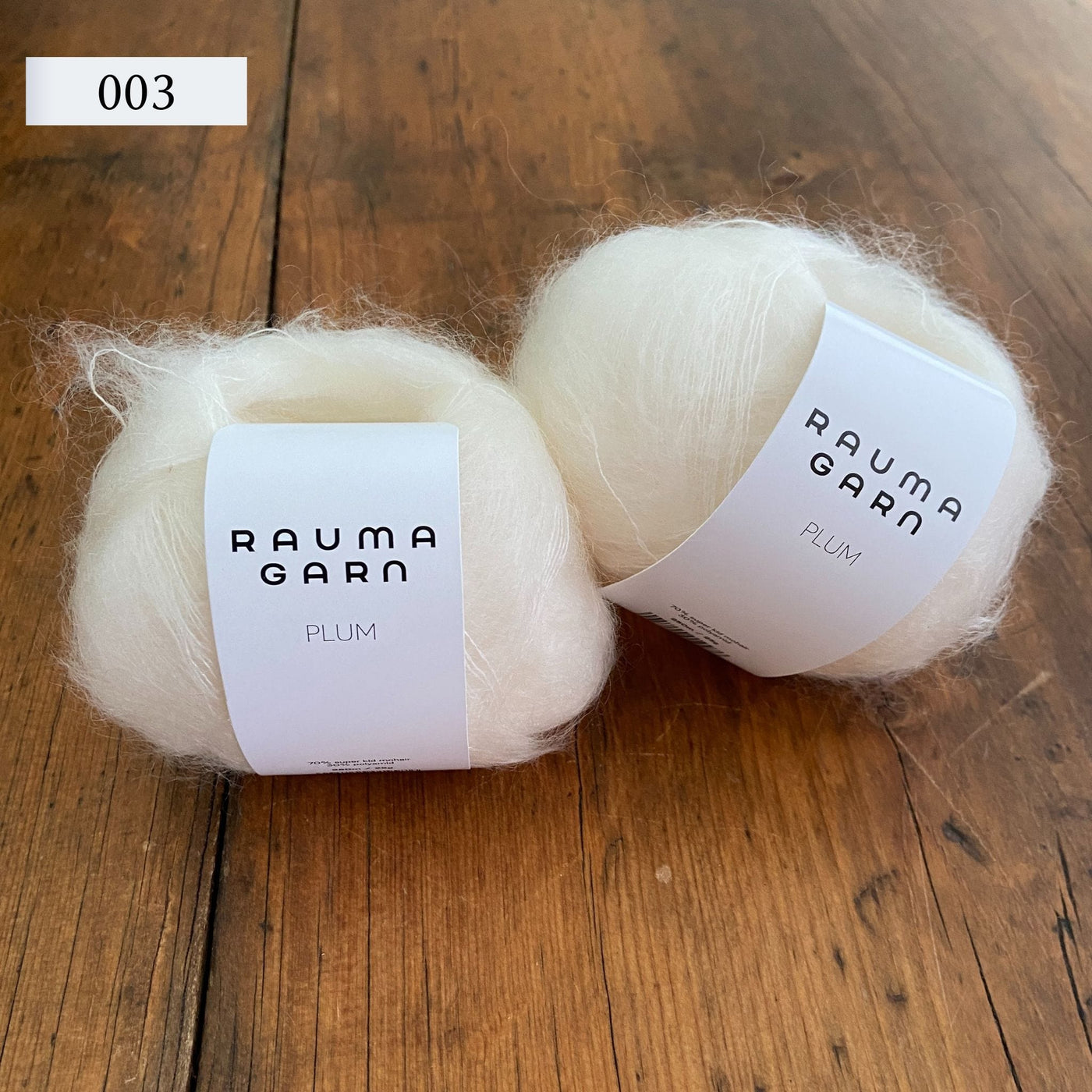 Two balls of Rauma Plum, a laceweight mohair blend yarn, in color 003, a cream color