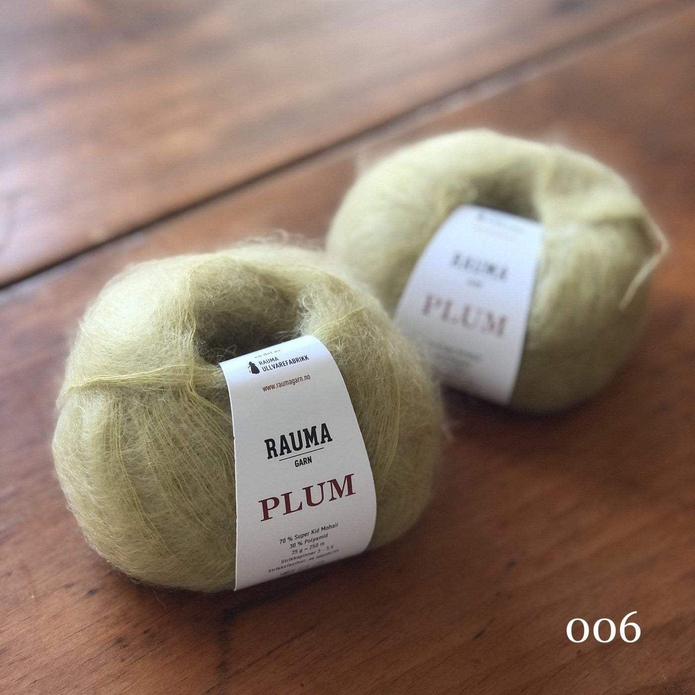 Two balls of Rauma Plum, a laceweight mohair blend yarn, in color 006, a light pastel green