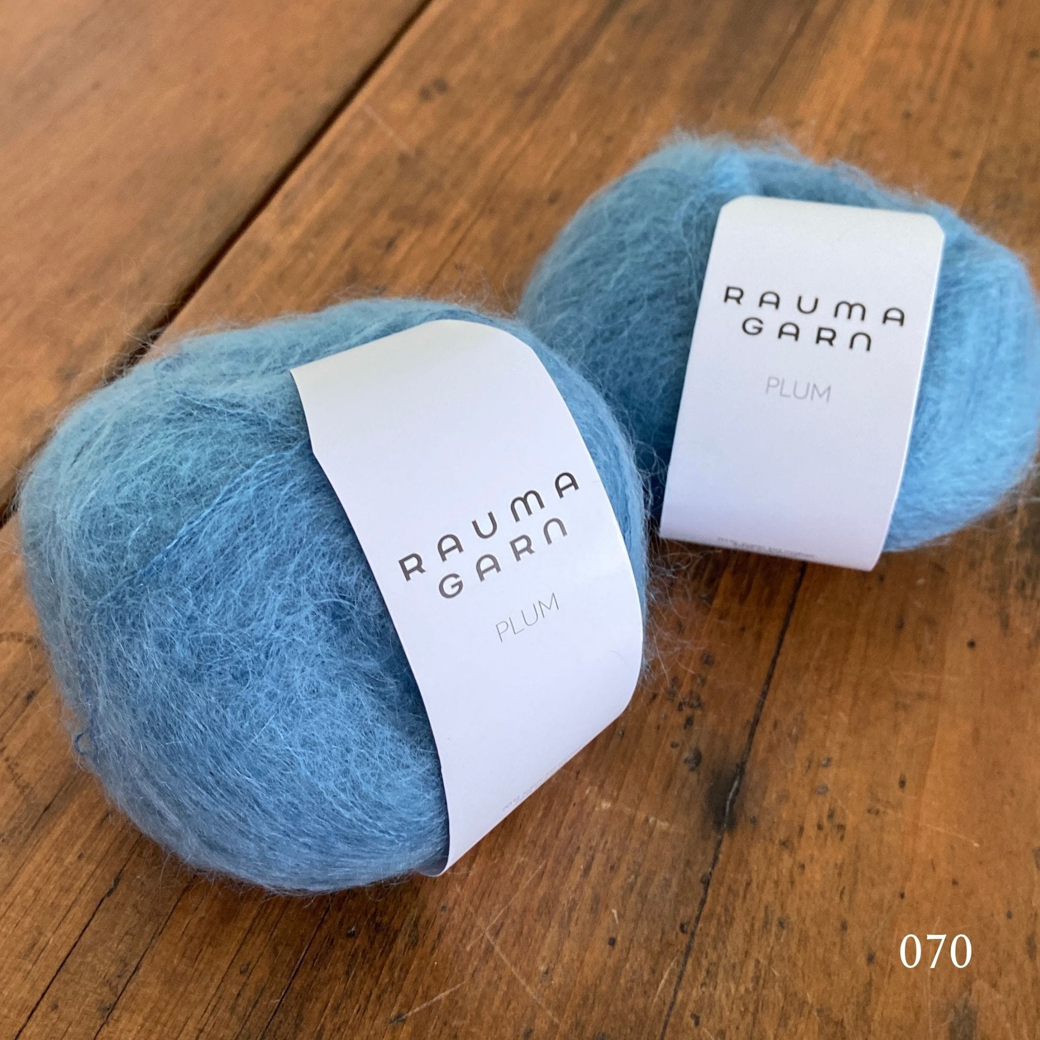 Two balls of Rauma Plum, a laceweight mohair blend yarn, in color 070, a baby blue