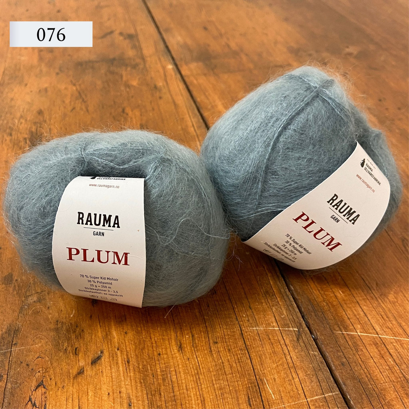 Two balls of Rauma Plum, a laceweight mohair blend yarn, in color 076, light blue.