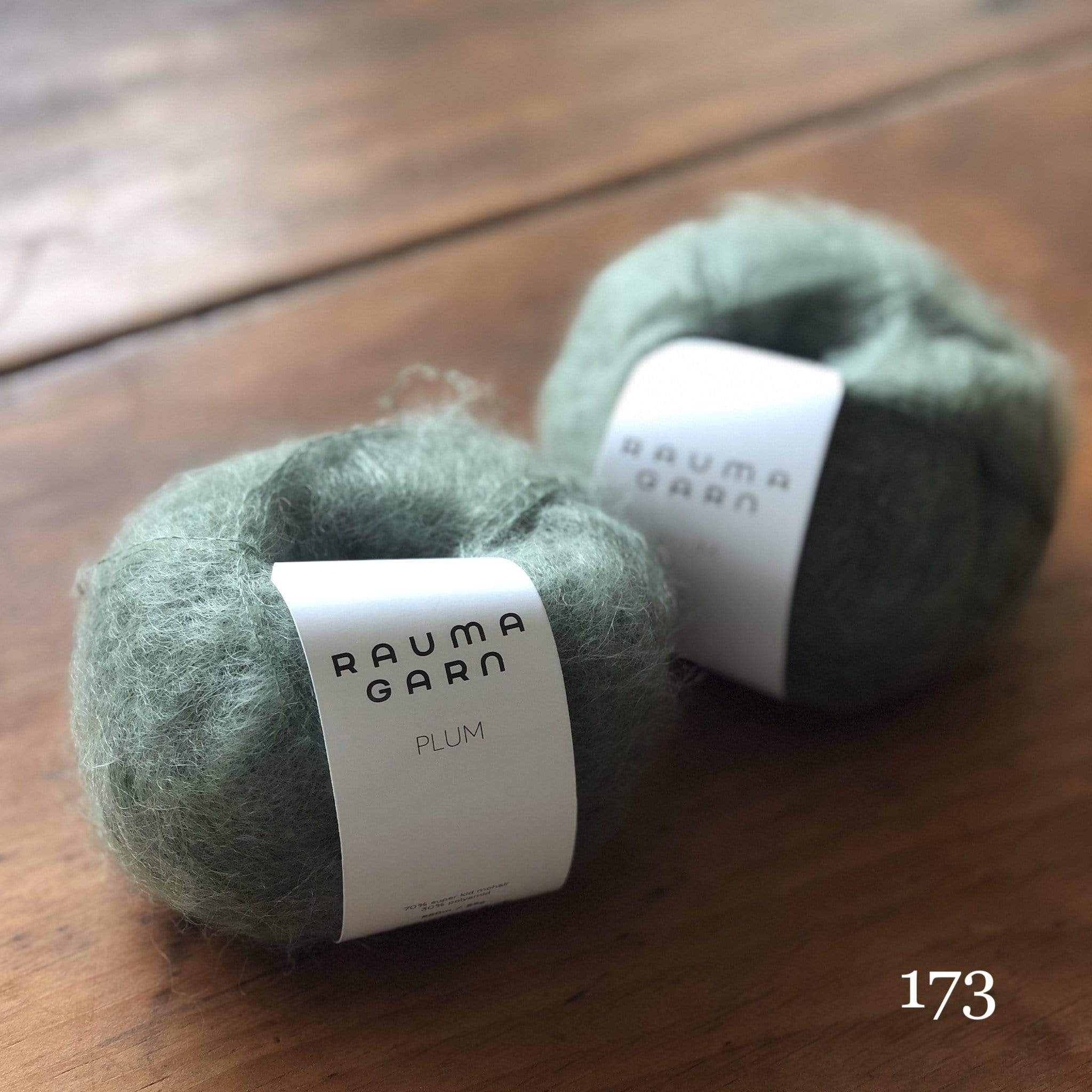 Two balls of Rauma Plum, a laceweight mohair blend yarn, in color 173, a stone green