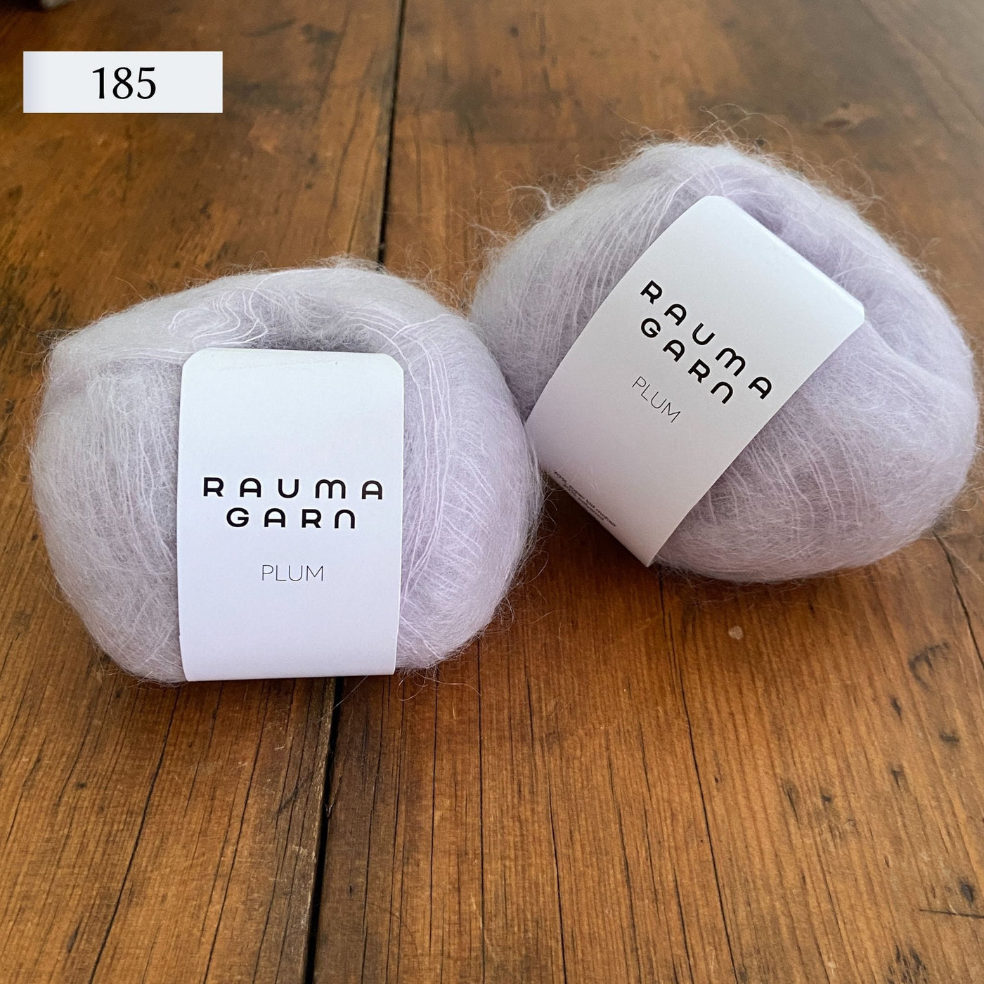 Two balls of Rauma Plum, a laceweight mohair blend yarn, in color 185, a very light lavender/cream